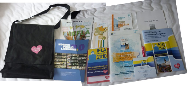 Eine Tasche mit "Bibliotheksliebhaber" darauf und einige Bücher auf einem Bett.