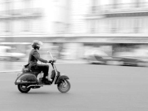 Eine Person fährt ein Scooter auf einer Straße.