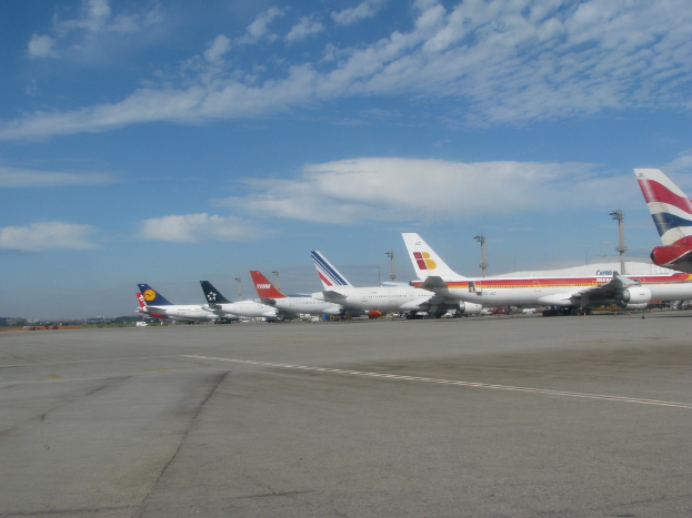 Eine Startbahn mit einigen Flugzeugen, Polen, Kabeln und einer bewölkten Himmel
