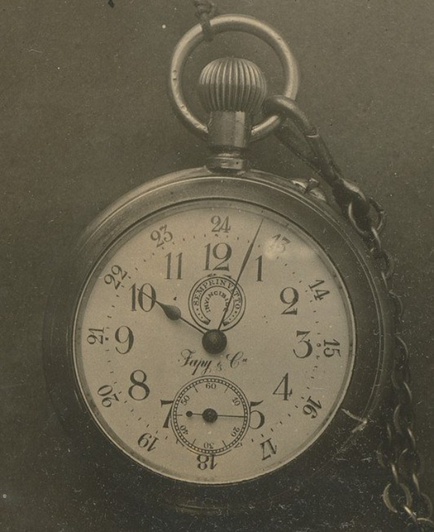Altes Schwarz-Weiß-Foto einer Taschenuhr mit Kette, mit einer nummerierten Zifferblättern.
