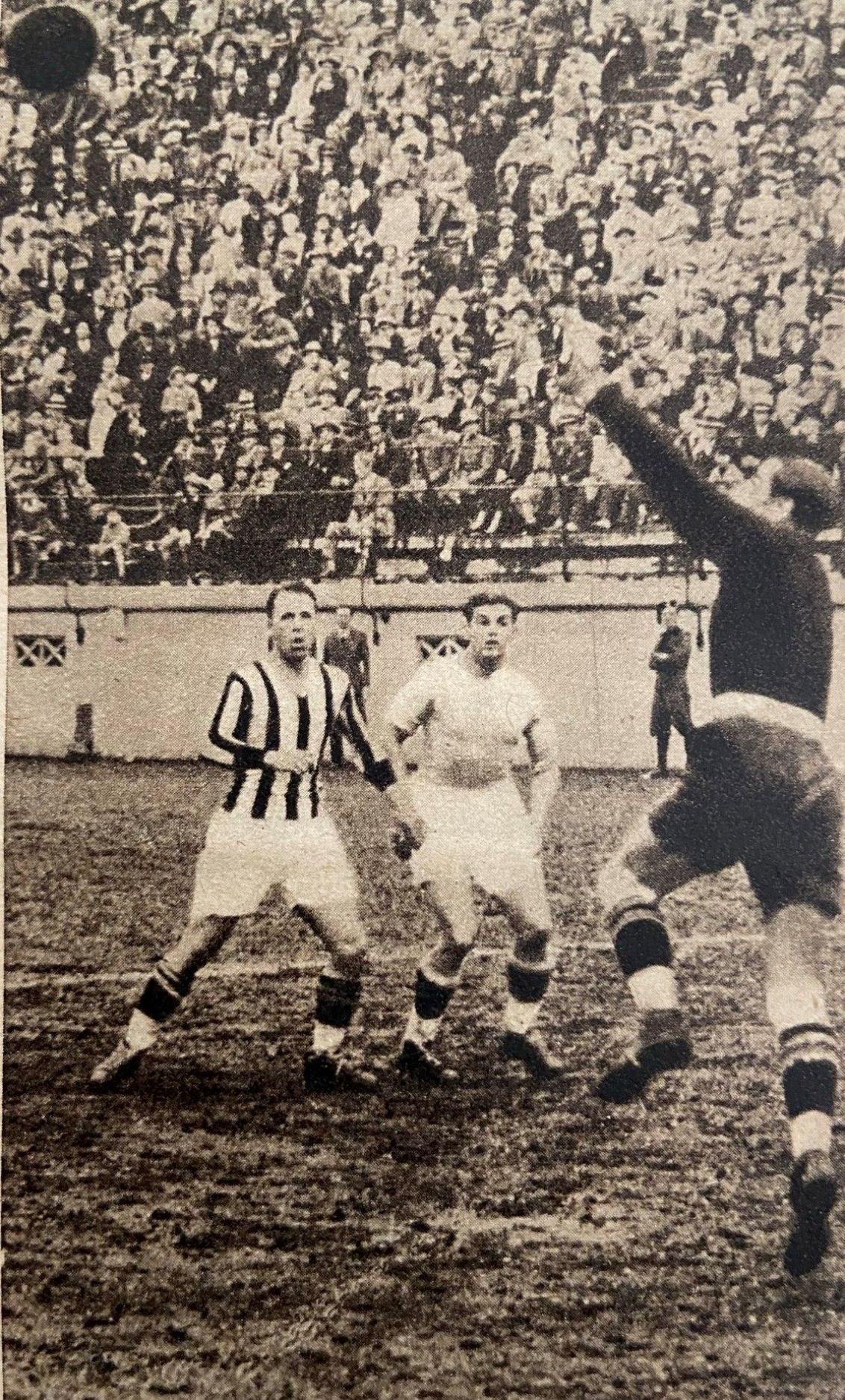 Schwarzes und weißes Foto von Männern, die auf einem Feld Fußball spielen, mit Zuschauern auf den Tribünen und einer Wand im Hintergrund, beschriftet mit "Newcastle United v West Bromwich Albion".