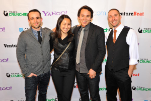 Eine Gruppe strahlender Menschen posiert für die Kamera mit einem Sponsorenbanner im Hintergrund.