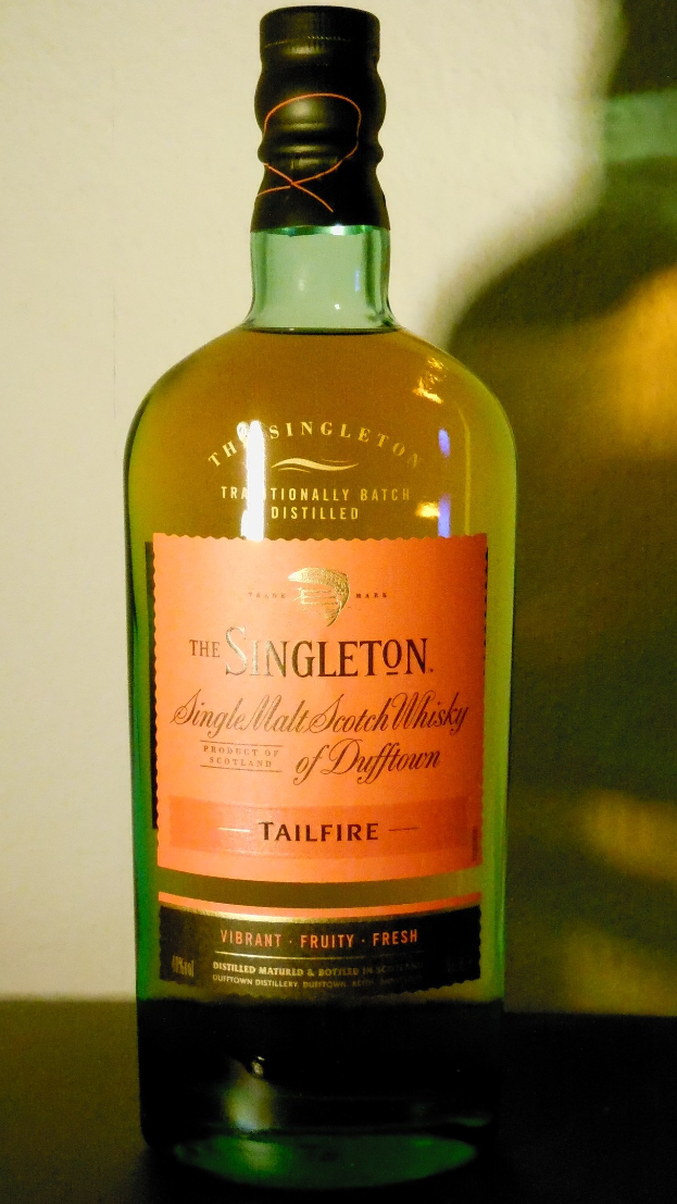 Tiefe bernsteinfarbene Flasche Singleton of Dufftown Tailfire Single Malt Scotch Whisky mit schwarzer Etikett mit einem Löwen und einem Burgwappen.