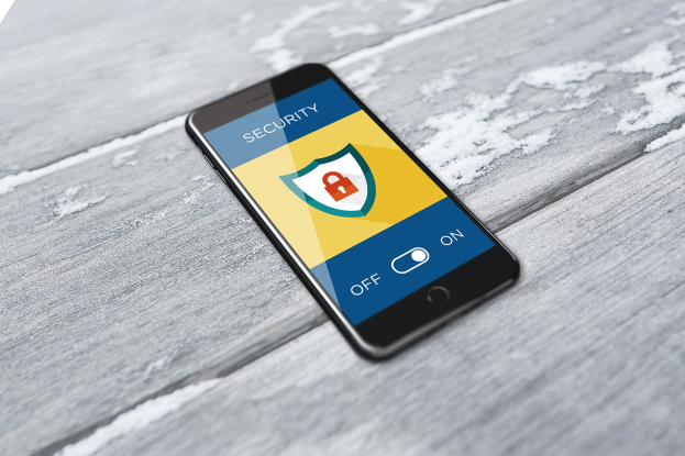Ein Smartphone, das ein Sicherheits-Symbol und das Wort "Sicherheit" auf seinem Bildschirm anzeigt und auf einer hölzernen Oberfläche liegt, mit einem Wasserzeichen in der linken oberen Ecke.