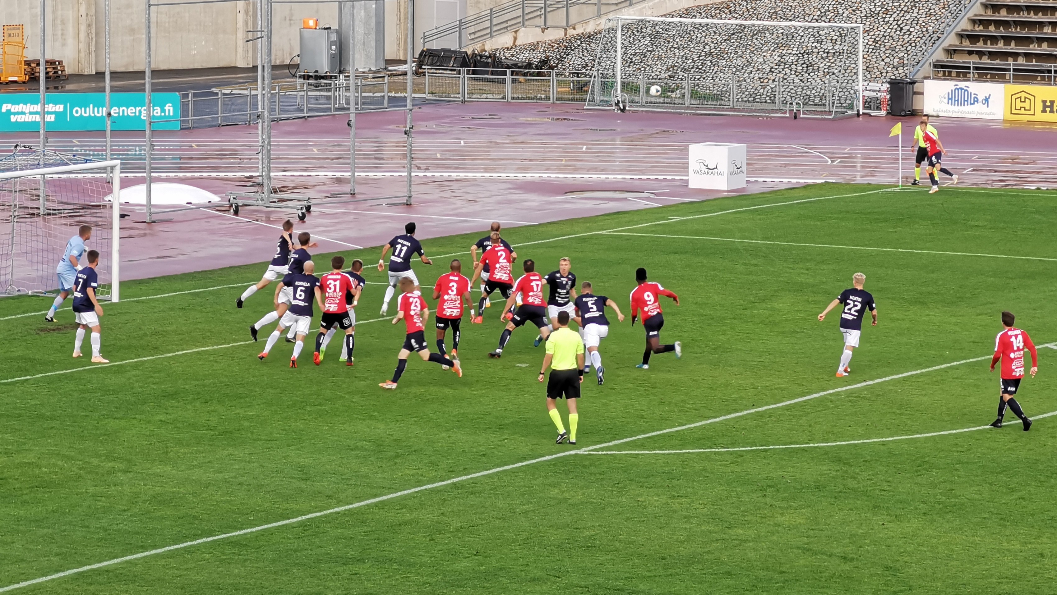 Eine Gruppe von Menschen, die Fußball auf einem Feld mit Zuschauern in einem Stadion spielen.