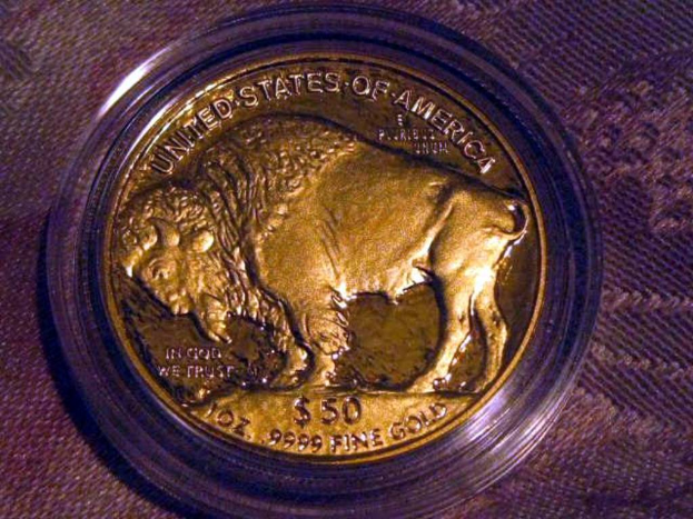 Eine gold- und braune M├╝nze mit der Aufschrift "The United States Of America" auf einem braunen Teppichhintergrund.