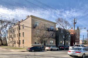 Eine Straßenszene mit parkenden Autos, Strommasten, Bäumen, Gebäuden und Laternen unter einem bewölkten Himmel, mit einem Wasserzeichen, das ein Mietobjekt an 5901 S Elmwood Avenue, Chicago 60618 anzeigt.