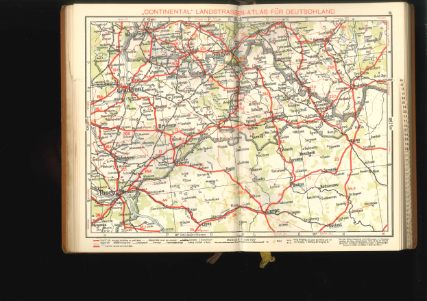 Offenes Buch mit detaillierter Deutschlandkarte auf schwarzem Hintergrund.