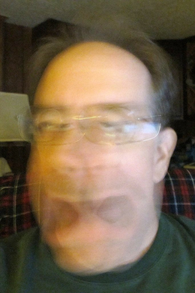 Ein unscharfer Bild eines Mannes mit Brille.