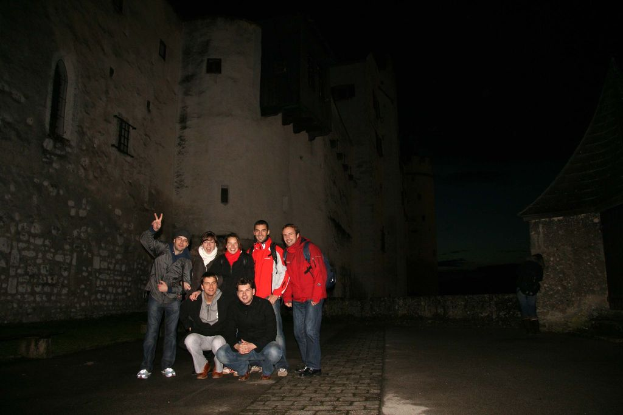 Menschen, die in der Mitte einer nächtlichen Szene mit einer Burg im Hintergrund stehen