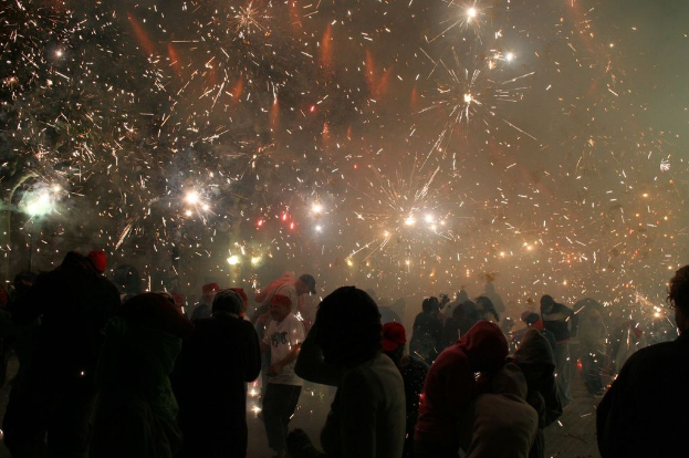 Eine große Gruppe von Menschen steht im Freien und zündet Feuerwerk.