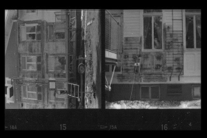 Ein Schwarz-Weiß-Foto eines feuerbeschädigten Gebäudes mit Fenstern, Leitern und anderen Gegenständen, mit Nummern am unteren Rand.
