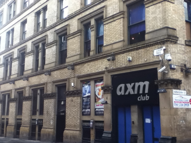 Ein Schaufenster mit Plakaten und einem GebÃ¤ude im Vordergrund.