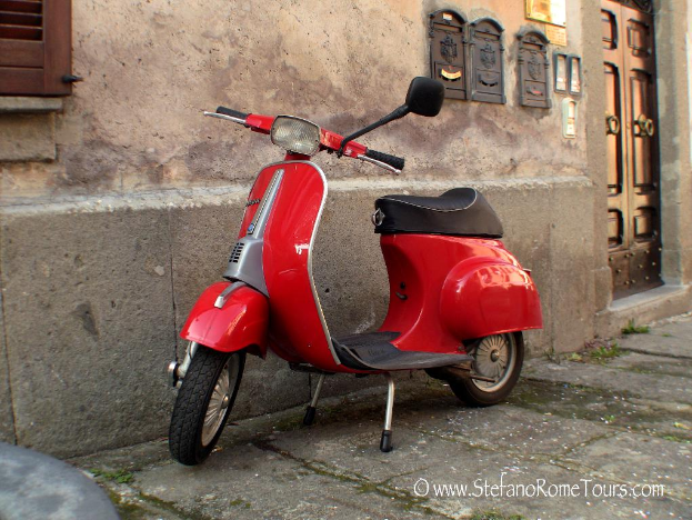 Ein roter E-Scooter steht vor einem Haus mit einer Tür und Fenstern auf einer Straße mit Text unten.