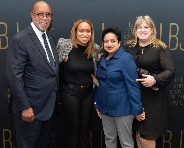 Vier Personen auf einem roten Teppich bei der "Liberty Justice for All Awards"-Veranstaltung, die fröhlich für ein Foto posen.