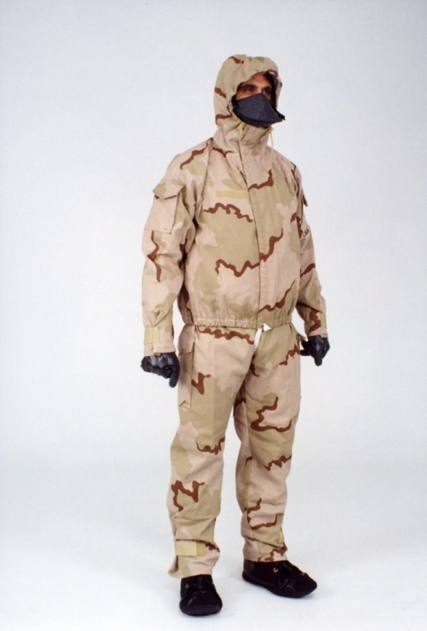 Mann in einem Tarnmuster-Schutzoverall mit Kapuze und Maske, der vor einem weißen Hintergrund steht.