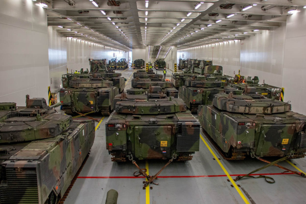 Ein grosser Militaraustellungsraum mit Reihen von Militaraezugfahrzeugen, Wänden auf beiden Seiten und Deckenbeleuchtung.