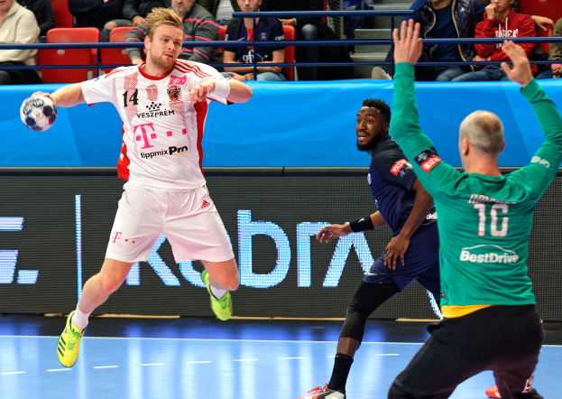 Eine Gruppe von Männern, die Handball auf einem Platz spielen, mit einem Ball in der Mitte der Aktion und Zuschauern im Hintergrund bei der Futsal-Weltmeisterschaft 2019, die Bayern München gegen Paris Saint-Germain beobachten.