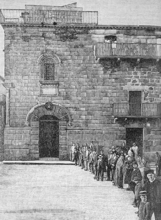 Eine Gruppe von Menschen steht vor einem Gebäude mit Fenstern, Geländern und einer Tür, mit dem Text "Jüdische Gefangene am Eingang zur Synagoge in Jerusalem" am unteren Rand des Schwarz-Weiß-Bildes.
