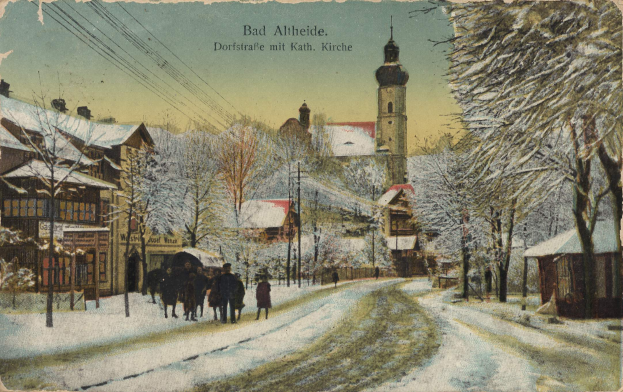 Eine alte Postkarte zeigt eine verschneite Straße in Bad Altenbürg, Deutschland, mit Menschen, die spazieren gehen, gesäumt von Bäumen, Pfählen und Gebäuden und einem Himmel im Hintergrund, mit Text oben.
