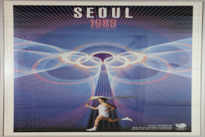 Eine Person, die mit den Olympischen Ringen im Hintergrund läuft und die Wörter "Olympische Spiele" darüber geschrieben hat, bewirbt die Olympischen Spiele 1988 in Seoul, Südkorea.