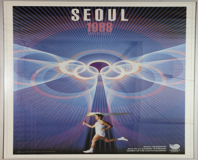 Eine Person, die mit den Olympischen Ringen im Hintergrund läuft und die Wörter "Olympische Spiele" darüber geschrieben hat, bewirbt die Olympischen Spiele 1988 in Seoul, Südkorea.