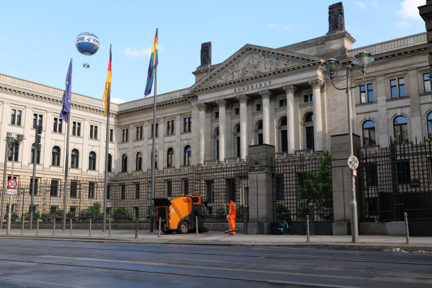Großes modernes Gebäude mit vielen Fenstern, als Bundestag in Berlin, Deutschland identifiziert, umgeben von Straßennetz und Füügängern, unter einem bewölktem Himmel.